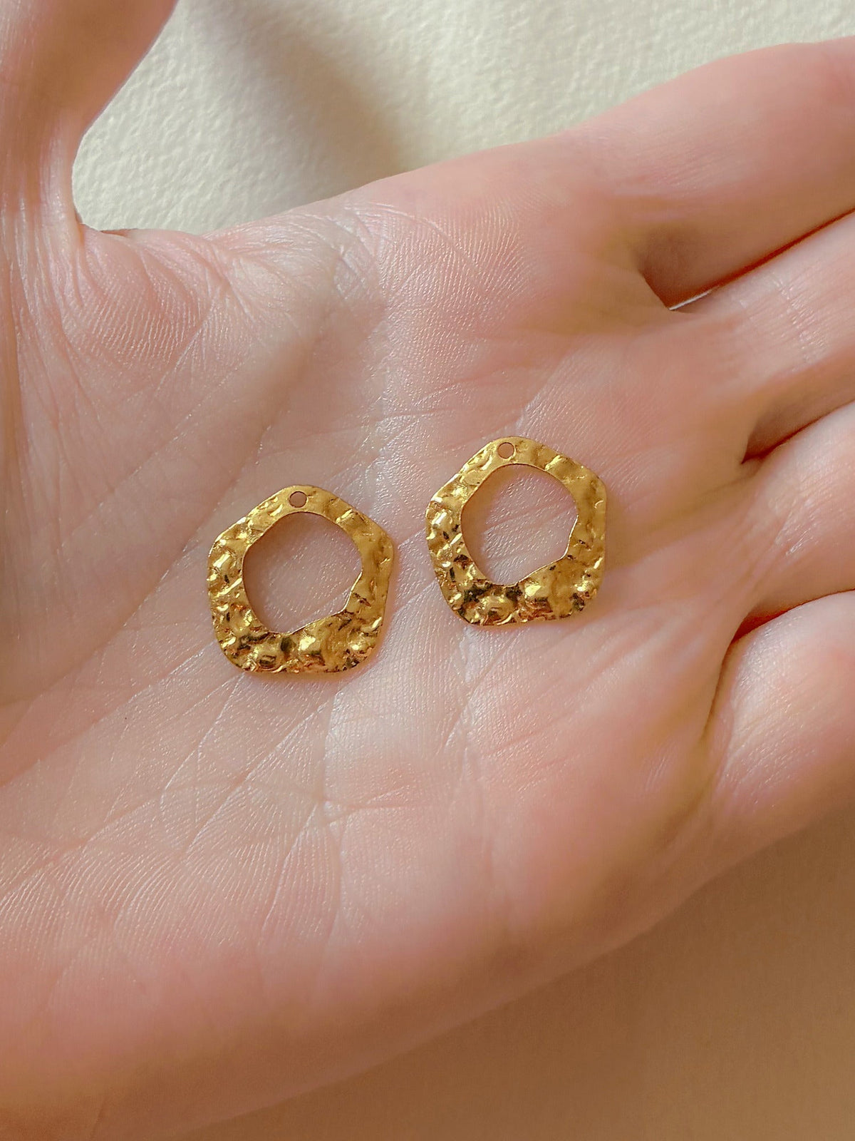 Bagstykke hamret ring i messing fra Winther Design, holdt i hånden