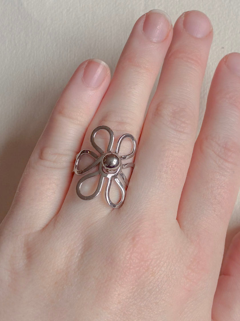 Vandfast ring i kirurgisk stål med blomst på hånden