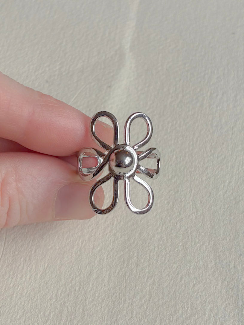 Vandfast ring i kirurgisk stål med blomst set fra siden