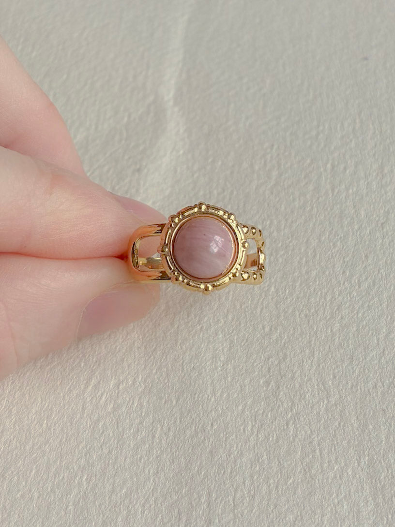 Vandfast forgyldt ring med rosa sten set fra siden